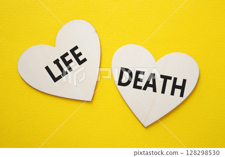 Life or Death symbol. Concept word Life or Death on wooden hearts. Beautiful yellow background. Business and Life or Death concept. Copy space Life or Death symbol. Concept word Life or Death on wooden hearts. Beautiful yellow background. Business and Life or Death concept. Copy space 128298530