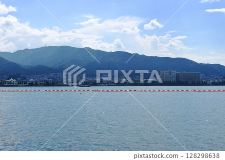 夏日天空下波光粼粼的琵琶湖湖面，以及對岸的城市與山脈 128298638