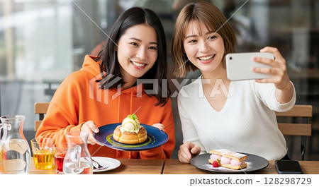 Two women taking a selfie in a cafe 128298729