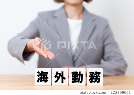 Middle-aged female business woman wearing a suit with a block of overseas work Middle-aged female business woman wearing a suit with a block of overseas work 128299601