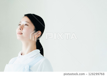 A young woman in an apron A young woman in an apron 128299768