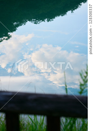 Clouds reflected on the surface of the pond Clouds reflected on the surface of the pond 128300337