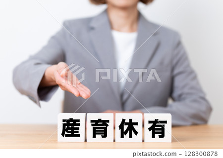 A middle-aged female business woman wearing a suit and a block with maternity and childcare leave 128300878
