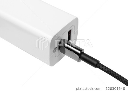 White power bank with connected USB cable on white background. 128301648