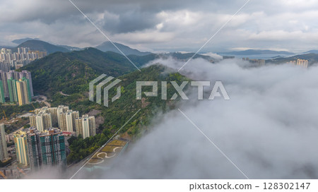 March 2 2025 View of Urban Skyline Meeting Green Hills and Dense Clouds March 2 2025 View of Urban Skyline Meeting Green Hills and Dense Clouds 128302147