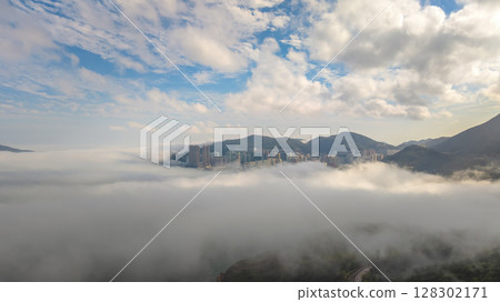 March 2 2025 Cityscape Surrounded by Misty Mountains, Hong Kong 128302171