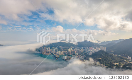 March 2 2025 Cityscape Surrounded by Misty Mountains, Hong Kong 128302180