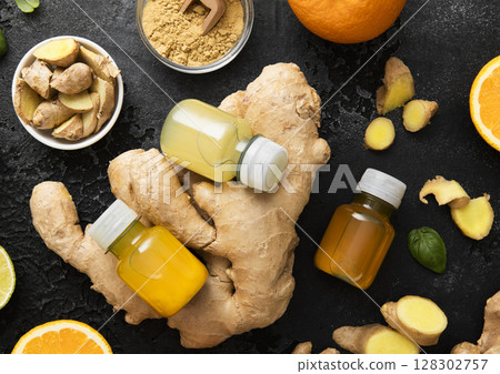 Bottles of immune ginger and orange energy shot drink with ginger root and turmeric powder. 128302757