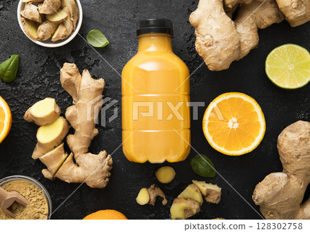 Immune ginger and orange energy shot drink with ginger root and turmeric powder on black. 128302758