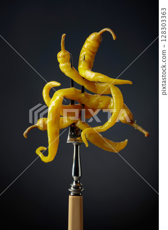 Canned yellow peppers on a black background. 128303363
