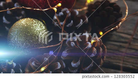 Image of glowing lights moving over christmas bauble and decorations 128303552