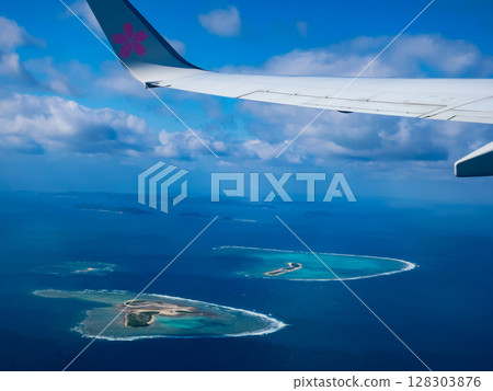 Spectacular view of the blue ocean and islands from the airplane window: Beautiful natural scenery from the sky 128303876