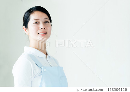 A young woman in an apron 128304126