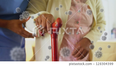Health worker helping senior woman walk, virus cells in background 128304399
