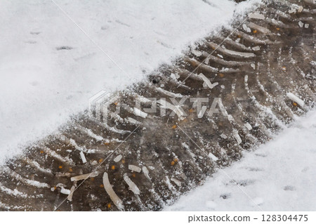 Tire tracks in fresh snow on a winter day demonstrate the effects of weather and travel in a quiet landscape Tire tracks in fresh snow on a winter day demonstrate the effects of weather and travel in a quiet landscape 128304475