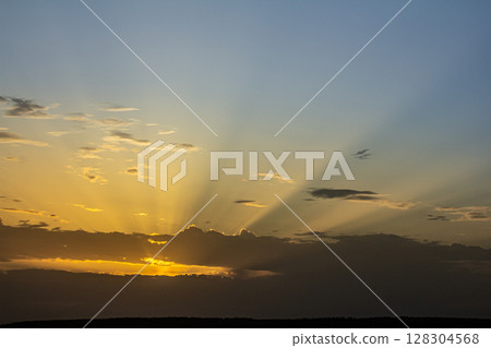 Stunning sunset casts vibrant rays across the sky creating a breathtaking view during twilight in the evening Stunning sunset casts vibrant rays across the sky creating a breathtaking view during twilight in the evening 128304568