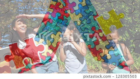 Image of colorful puzzle pieces over happy playing children 128305503