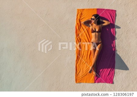 top view of a woman sunbathing on the beach top view of a woman sunbathing on the beach 128306197