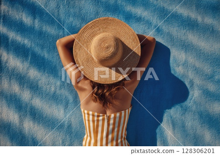 top view of a woman sunbathing on the beach 128306201