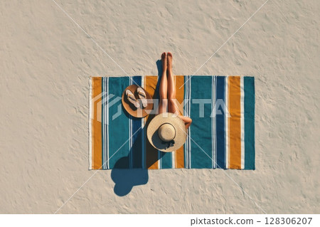 top view of a woman sunbathing on the beach 128306207