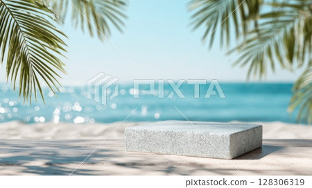 Beach sand with palm leaves and blue sky with a white stone podium in the foreground 128306319