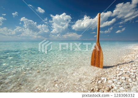 Wooden Paddle Standing on a Crystal Clear Pebble Beach Wooden Paddle Standing on a Crystal Clear Pebble Beach 128306332