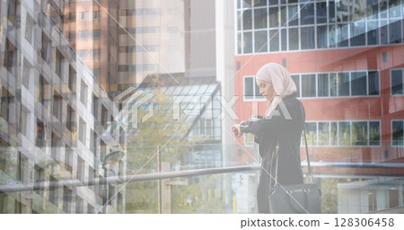 Image of asian woman in hijab using smartwatch over cityscape 128306458