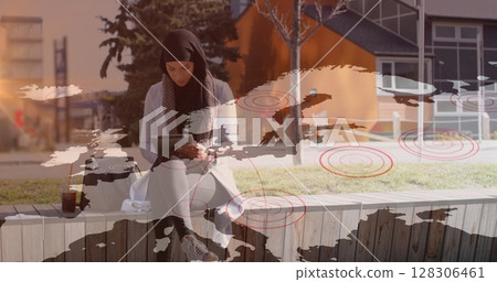 Image of asian woman in hijab using tablet in street over world map 128306461