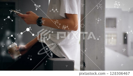 Young man holding coffee and smartphone, surrounded by floating scientific symbols Young man holding coffee and smartphone, surrounded by floating scientific symbols 128306467