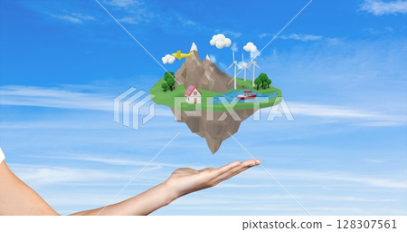 Hand holding floating island with house, wind turbines, and airplane in sky 128307561