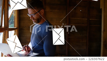 Man using laptop in rustic cabin, managing emails efficiently and focused Man using laptop in rustic cabin, managing emails efficiently and focused 128307622