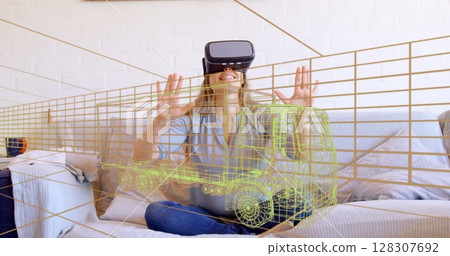 Image of 3d technical drawing of truck, over woman at home wearing vr headset Image of 3d technical drawing of truck, over woman at home wearing vr headset 128307692