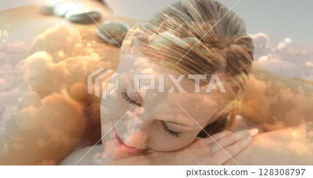 Beautiful blonde women lying at spa with hot basalt stone on the back and cloudscape for valentine d Beautiful blonde women lying at spa with hot basalt stone on the back and cloudscape for valentine d 128308797