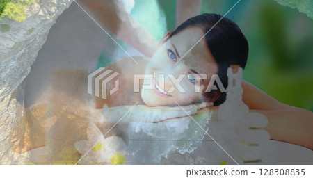 Smiling woman receiving massage over serene nature scene with waterfalls Smiling woman receiving massage over serene nature scene with waterfalls 128308835