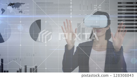 Wearing VR headset, woman interacting with virtual data and graphs over image 128308843