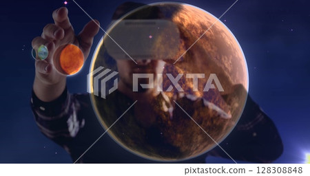 Using virtual reality headset, person exploring planets in space image Using virtual reality headset, person exploring planets in space image 128308848