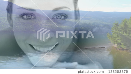 Smiling woman's face over serene lake and mountain landscape image Smiling woman's face over serene lake and mountain landscape image 128308876