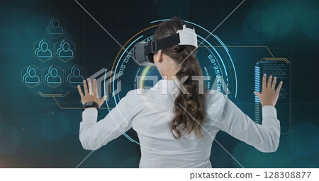 Using virtual reality headset, woman interacting with digital interface over network graphics 128308877