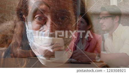 Young professionals collaborating on project in office, wearing masks for safety 128308921