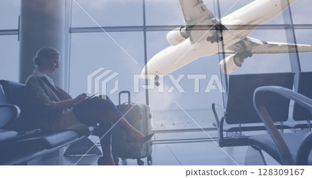 Image of airplane flying over female passenger using digital tablet sitting and waiting in airport l Image of airplane flying over female passenger using digital tablet sitting and waiting in airport l 128309167