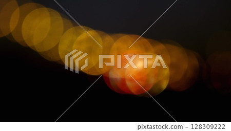 Image of multiple flickering yellow spots of light on black background Image of multiple flickering yellow spots of light on black background 128309222