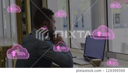Image of pink clouds with rising numbers and businessman using laptop in office Image of pink clouds with rising numbers and businessman using laptop in office 128309300