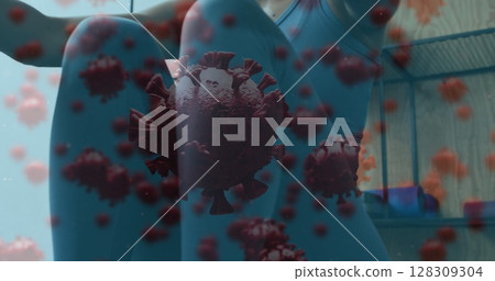 Covid-19 cells floating against woman wearing face mask performing rowing exercise at gym Covid-19 cells floating against woman wearing face mask performing rowing exercise at gym 128309304