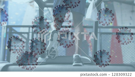 Image of covid-19 cells floating over african american man wearing face mask working out 128309322