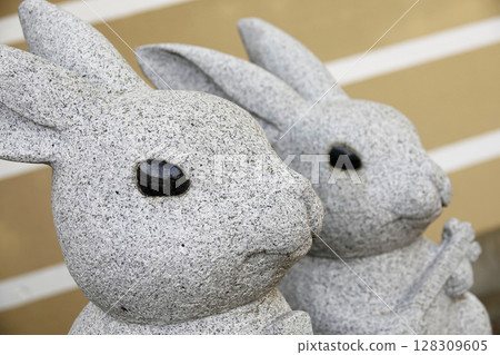 Cute stone rabbit statues can be seen here and there in the grounds of Izumo Taisha Shrine. Cute stone rabbit statues can be seen here and there in the grounds of Izumo Taisha Shrine. 128309605
