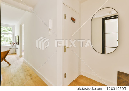 a hallway with a mirror on the wall and a table in the corner next to it, there is an open door that leads a hallway with a mirror on the wall and a table in the corner next to it, there is an open door that leads 128310205