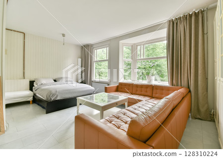 a bedroom with an orange couch and white bed in the room is very spacious, but it's not too 128310224