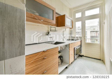 a kitchen with wooden cabinets and white counter tops on the floor in an empty room that has been used for many years 128310225