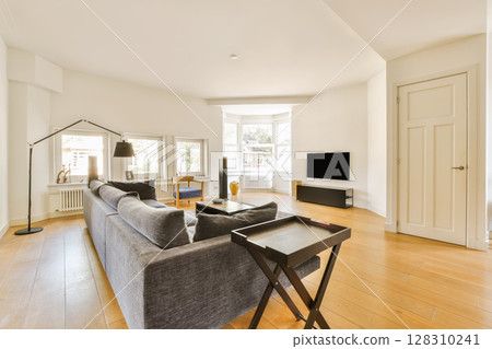 a living room with hardwood flooring and white walls in the center of the room is a couch, coffee table, tv stand a living room with hardwood flooring and white walls in the center of the room is a couch, coffee table, tv stand 128310241