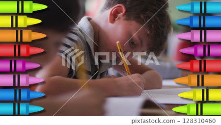 Digital composite image of colored crayons against school boy studying at school 128310460